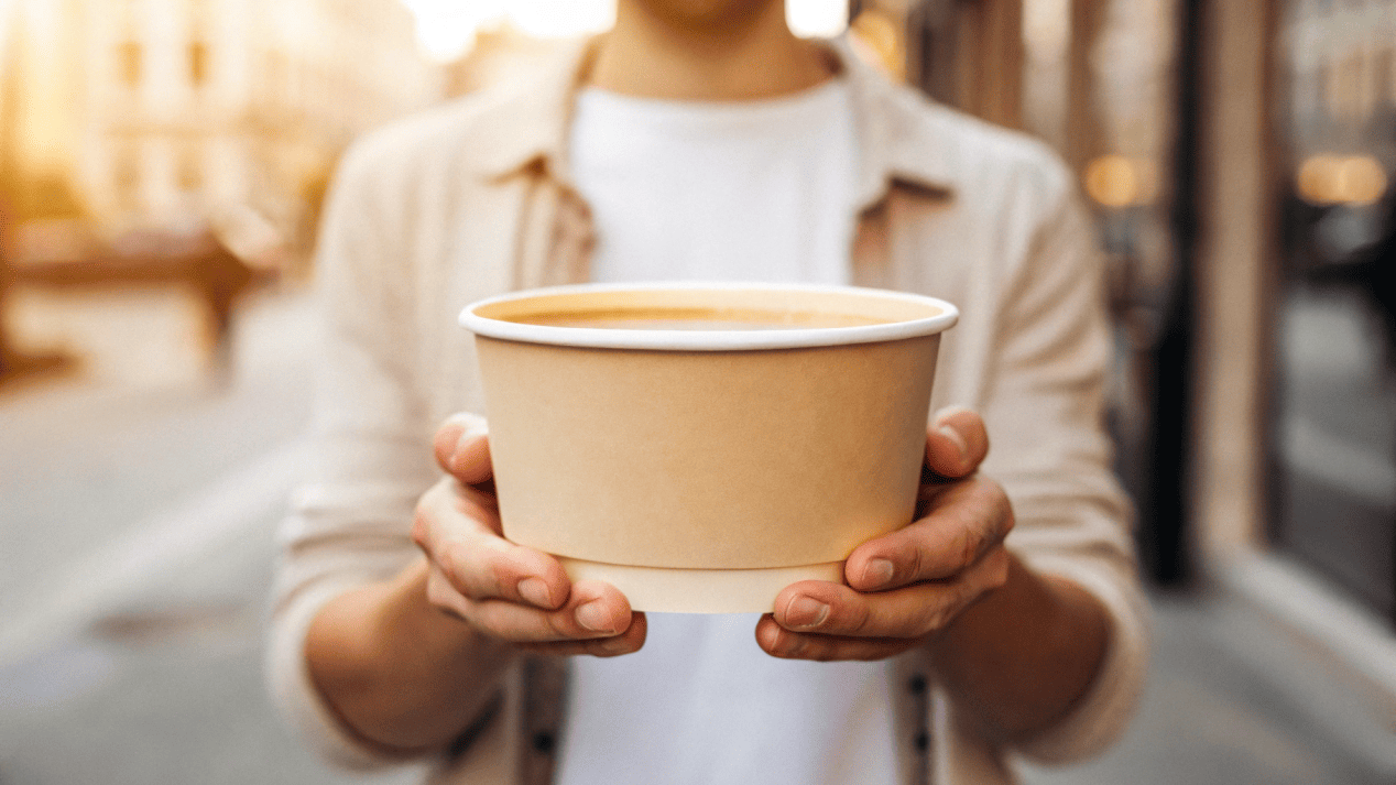 An Instagram-style photo of a person holding a branded soup bowl