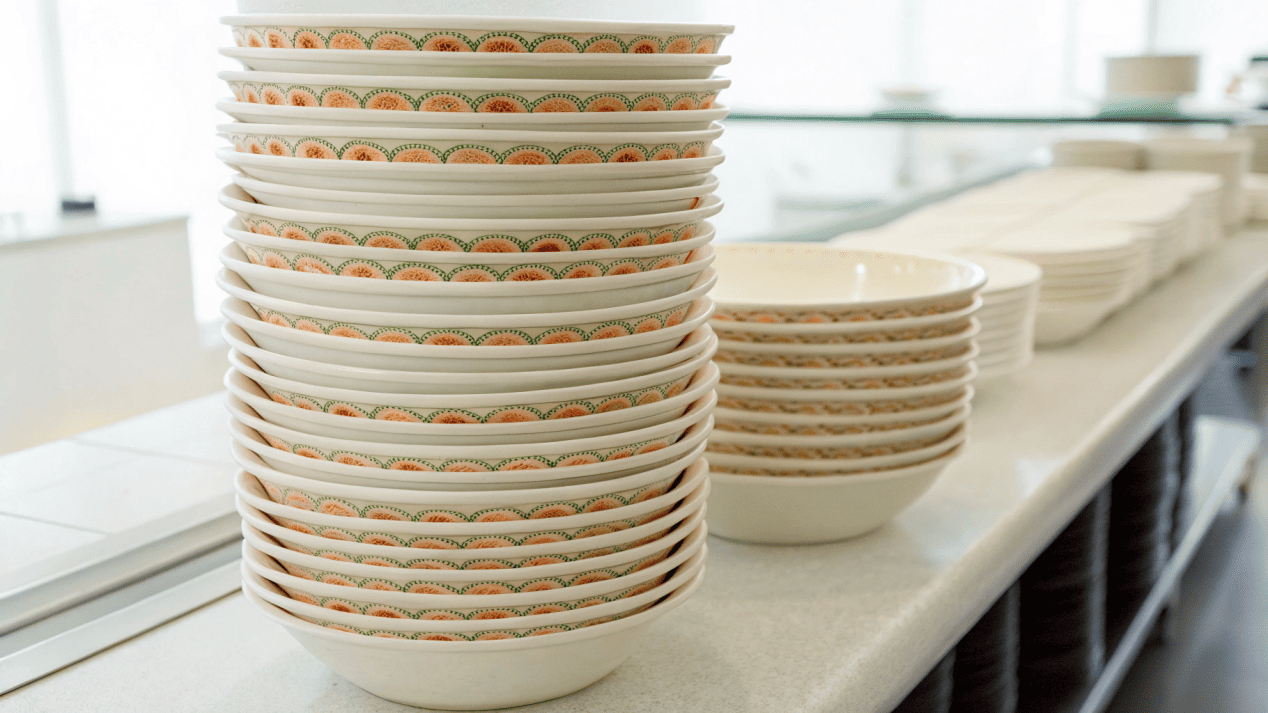 Stacks of tapered paper noodle bowls nested together, showing how they save space