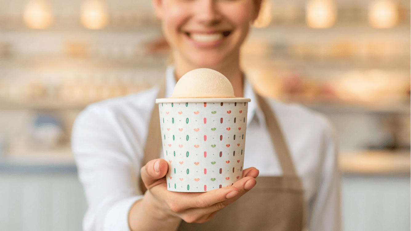 The Importance of Ice Cream Cups for Business A well-designed ice cream cup held by a happy customer, with a business owner smiling in the background.
