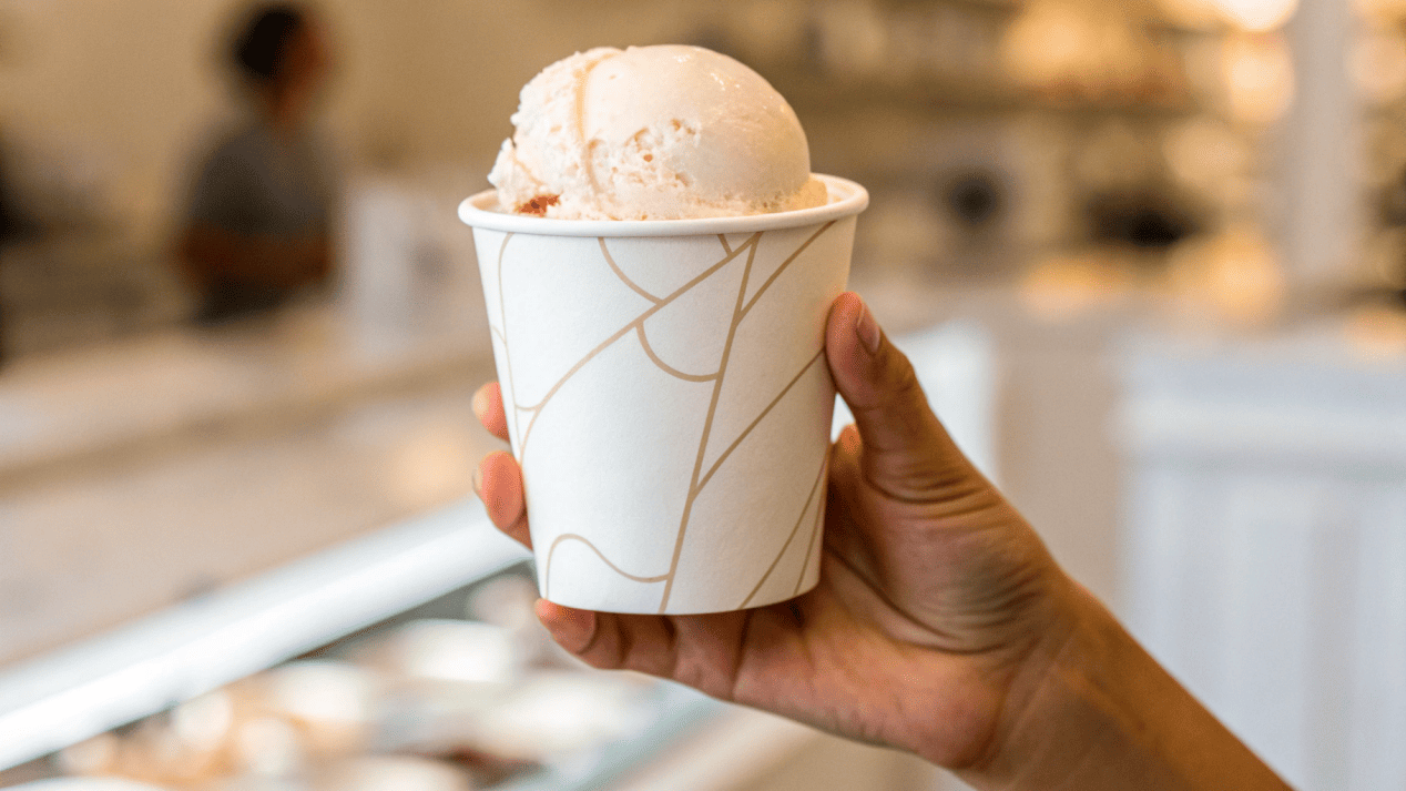 Customer Experience and Cup Quality A hand holding a sturdy, high-quality ice cream cup, conveying a premium feel.