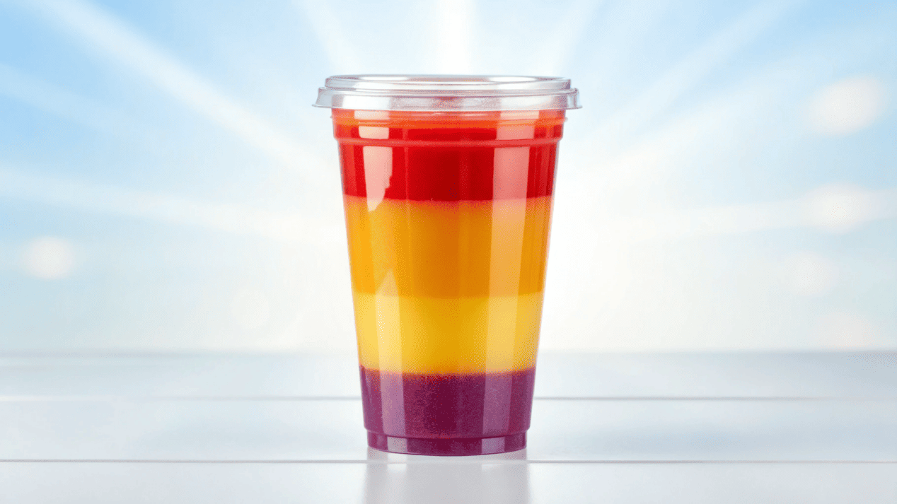 The Ultimate Guide to Compostable Clear PLA Cups A crystal-clear PLA cup filled with a colorful smoothie, showcasing its transparency.