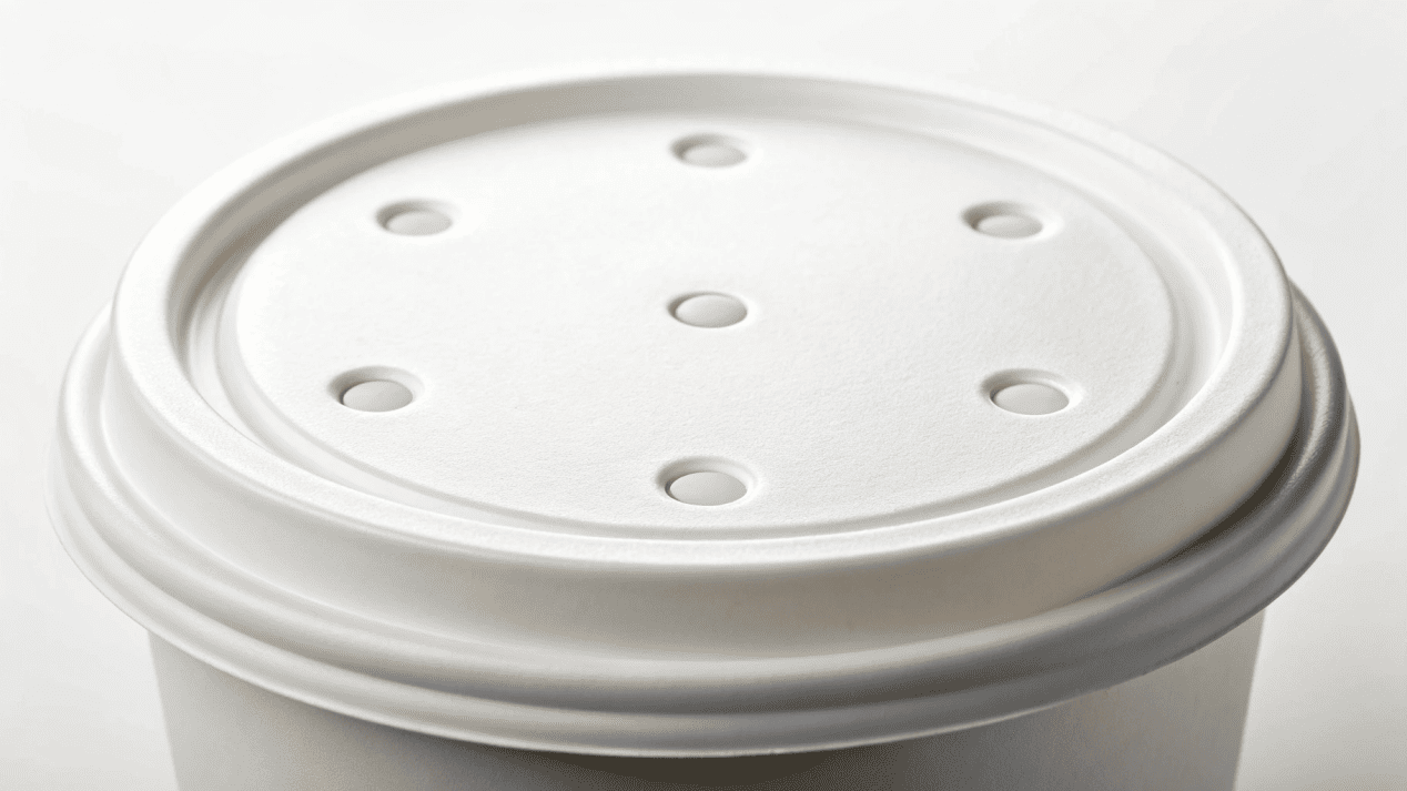 A close-up shot showing the small vent holes on a paper soup cup lid.