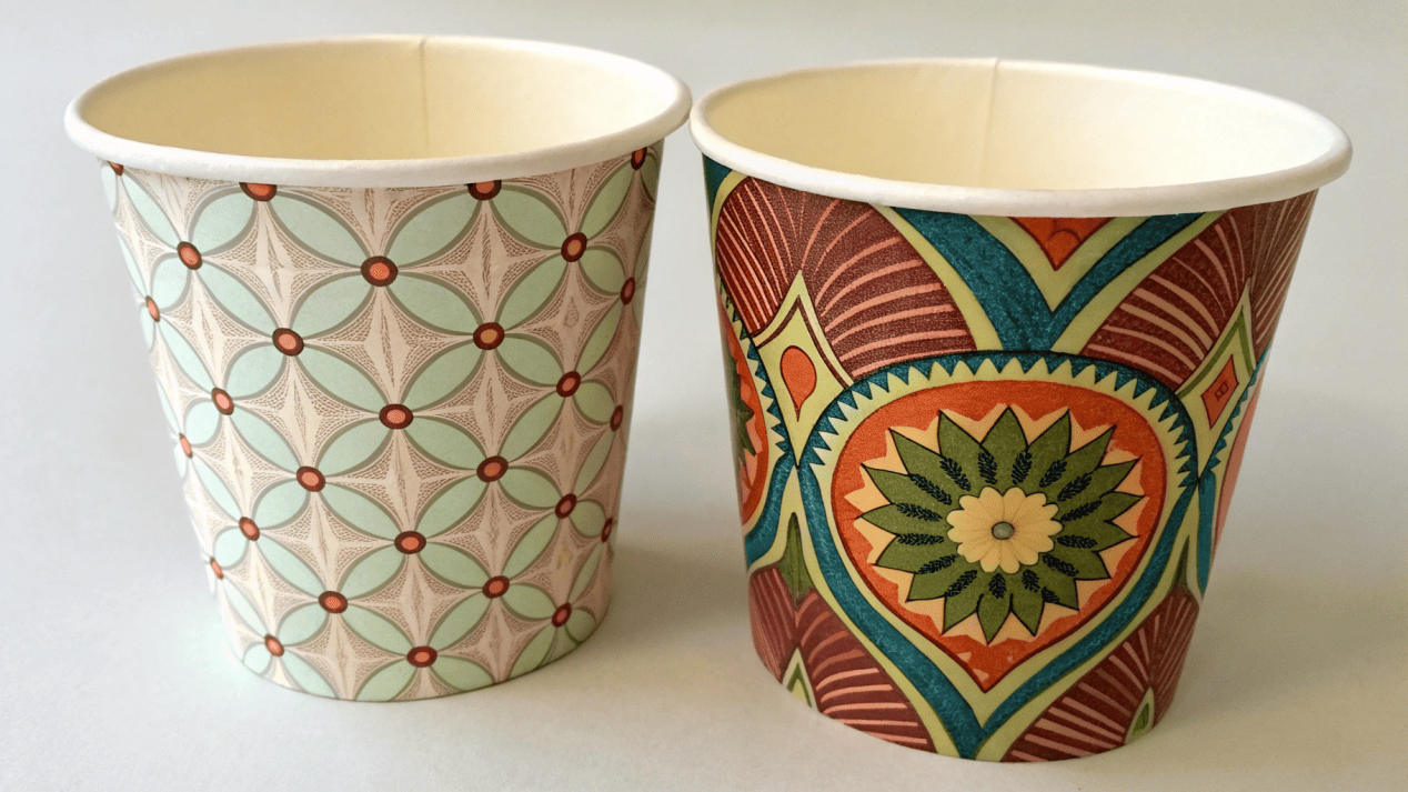 Two soup cups side by side, one with a simple flexo print and one with a complex offset print.