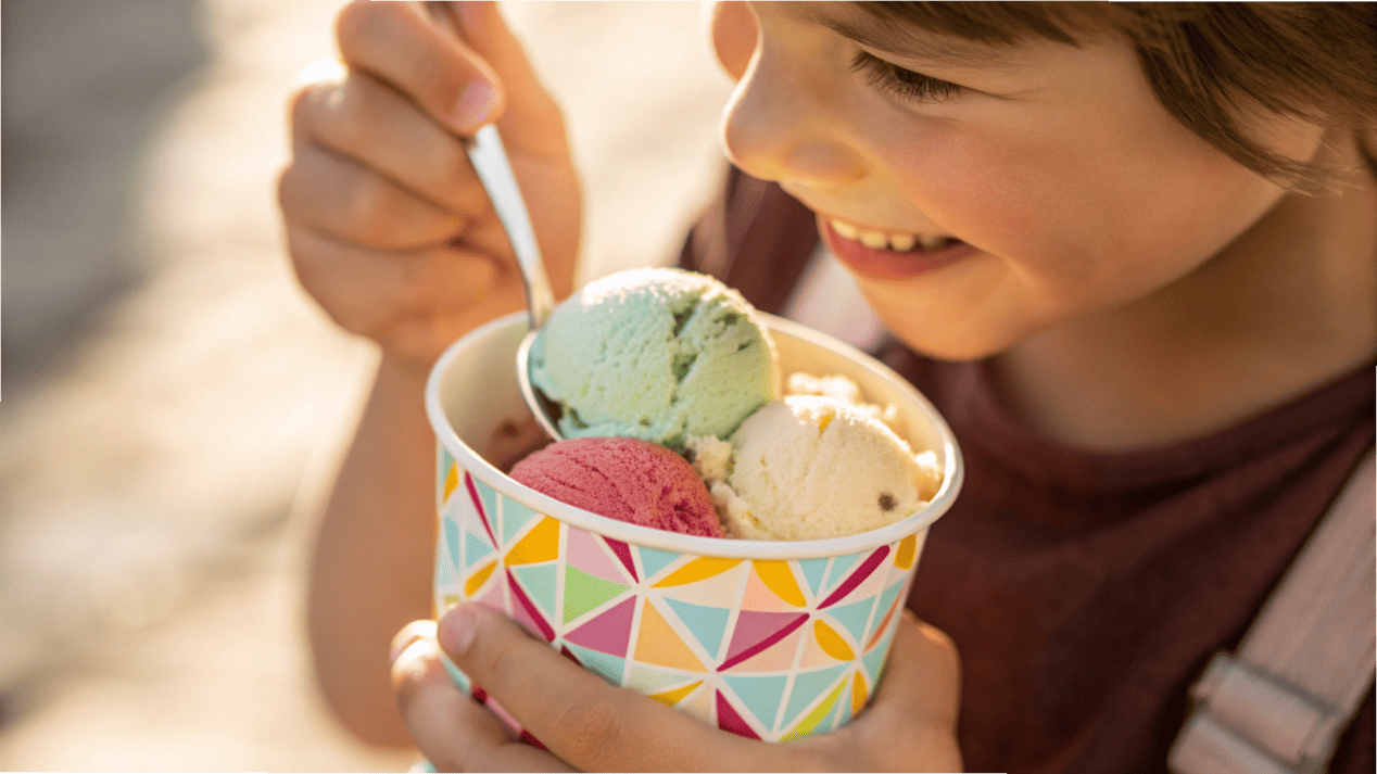 Branded Cups Build Customer Loyalty A close-up of a child happily eating from a branded ice cream cup.