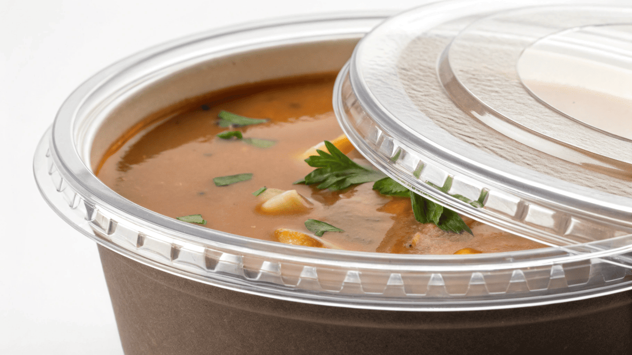 Precision-Fit Vented Lid System A close-up of a lid clicking securely onto the rim of a soup bowl, creating a tight seal.