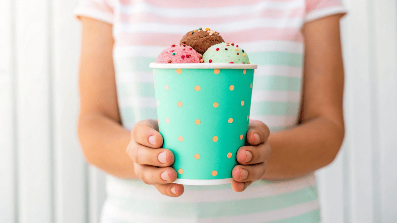 A person holding an 'Instagrammable' ice cream cup with a fun slogan.