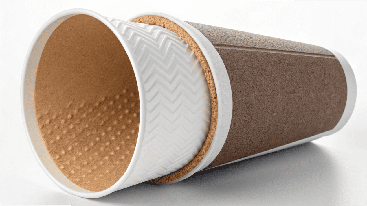 A cutaway view of a paper coffee cup showing the thin inner lining separate from the paper.