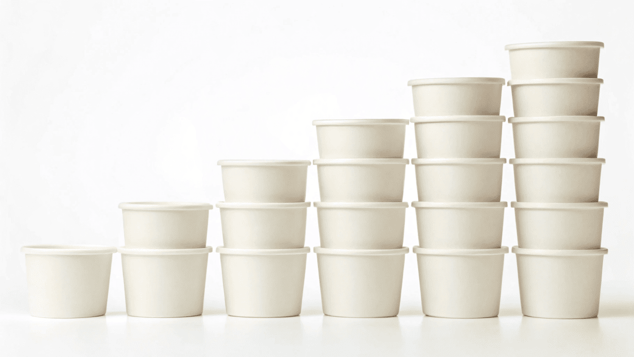 A lineup of different sized ice cream cups, from small to large.
