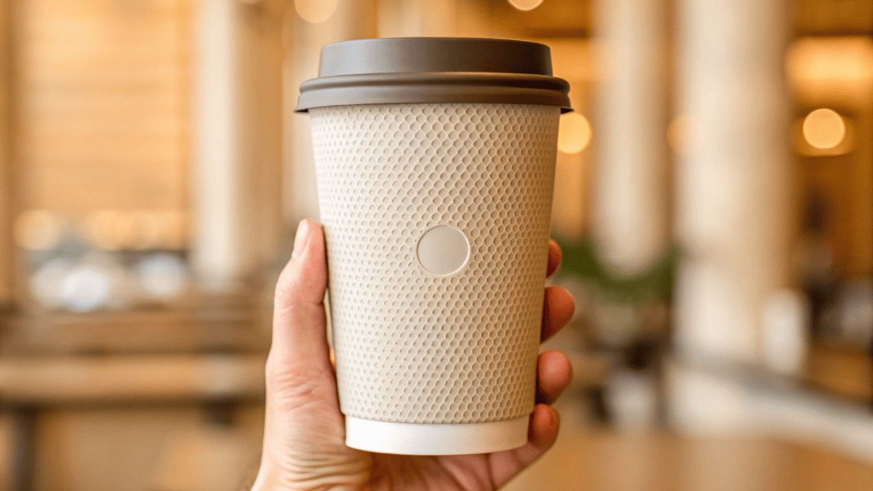Premium Feel of a Hotel Cup A guest's hand comfortably holding a thick, high-quality branded paper cup.