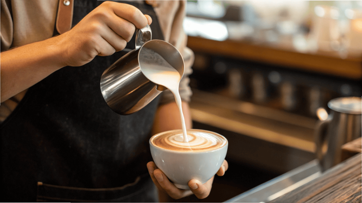 Cup as a Portion Control Tool A barista pouring milk into a latte cup that is exactly the right size for the drink.