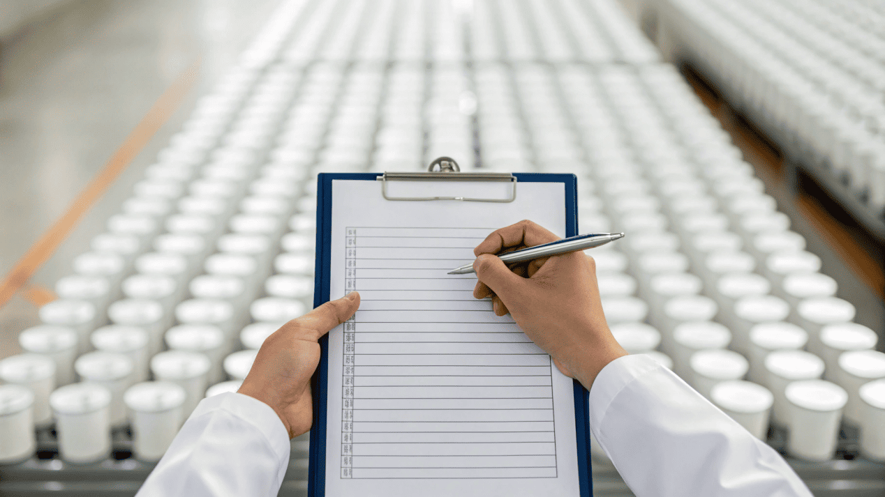 A person holding a checklist and pen, evaluating a paper cup supplier.