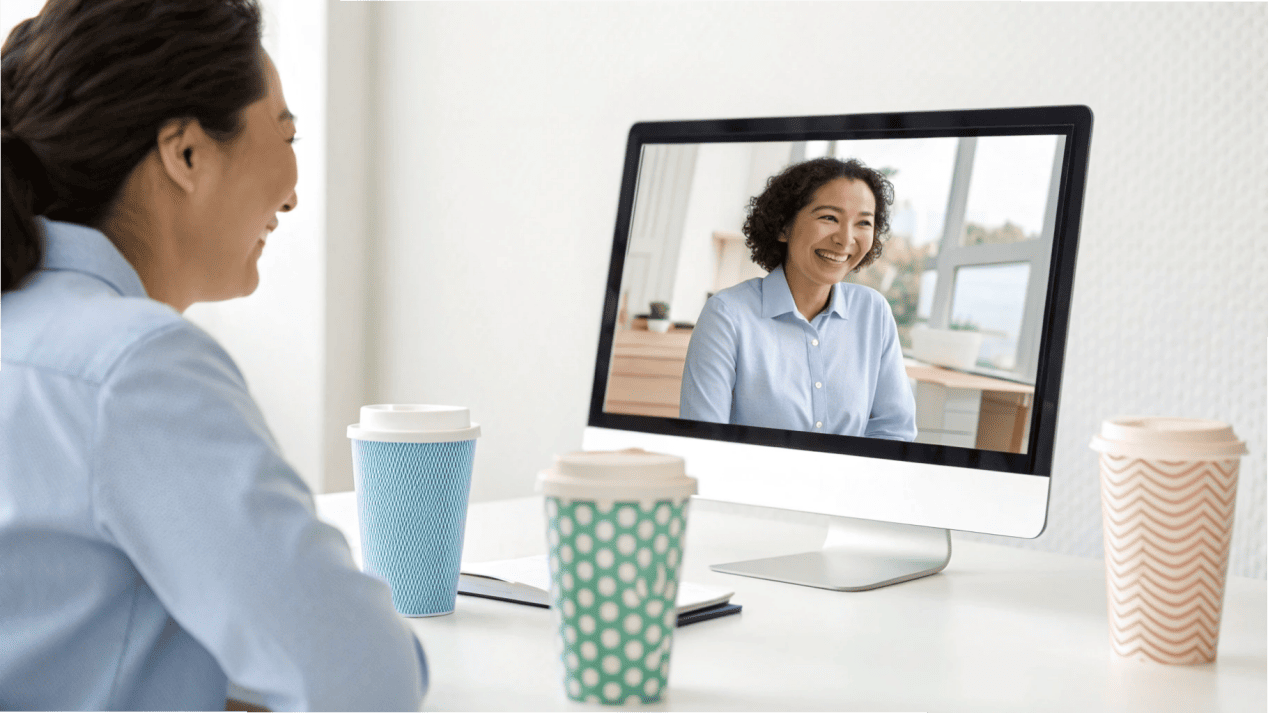 A friendly consultant discussing options with a client over a video call, with cup designs on the screen.