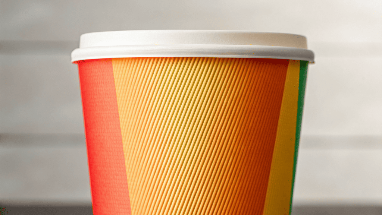 A close-up of a beautifully designed paper cup, showing off vibrant colors and crisp logo details.