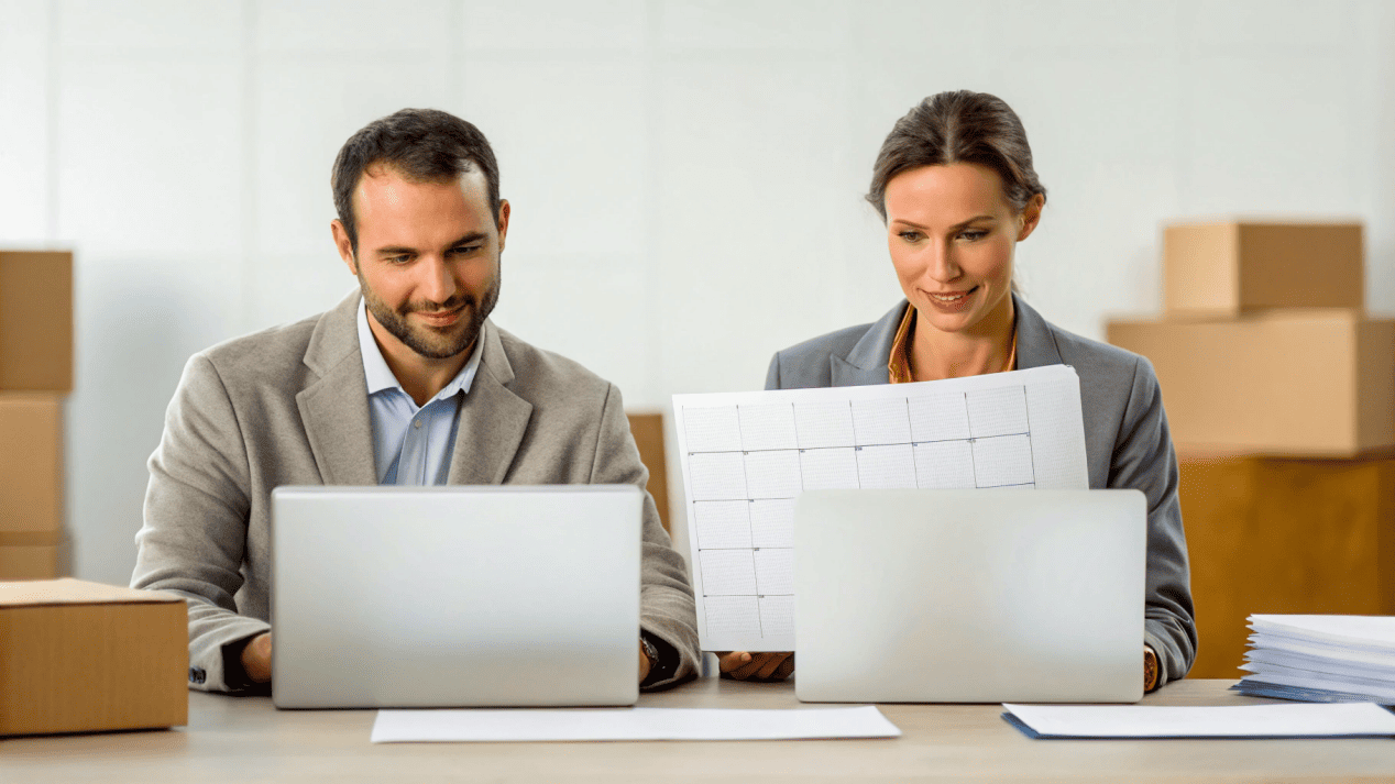 A packaging expert and an event planner looking at a calendar and logistical plan together.